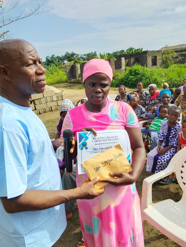 HTCF founder presenting support to a mother